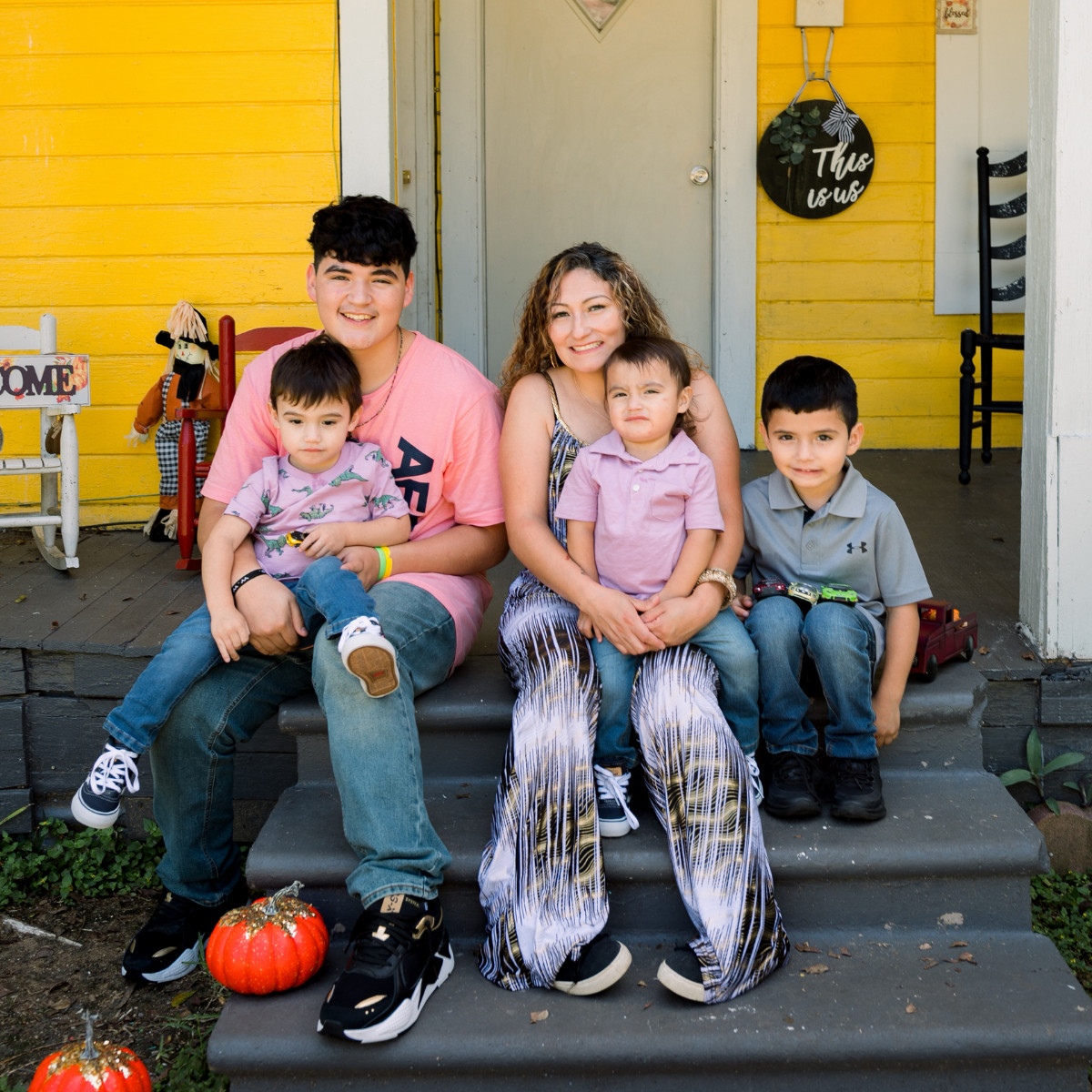 family smiling on front porch
